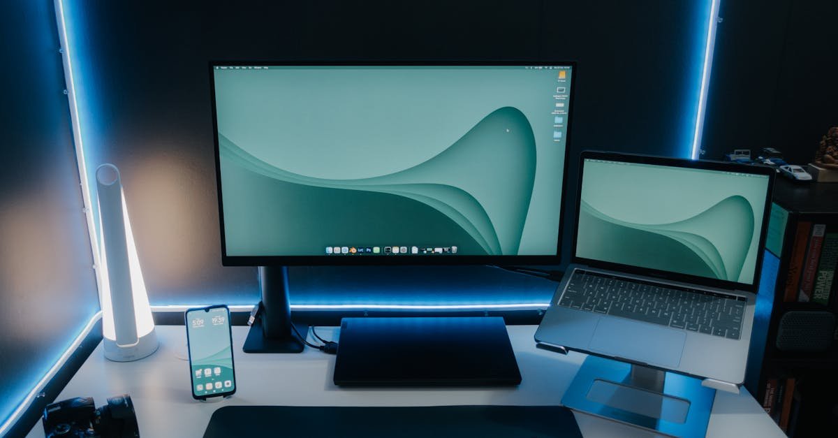 A sleek and modern desk setup featuring a monitor, laptop, and ambient lighting, perfect for productivity.