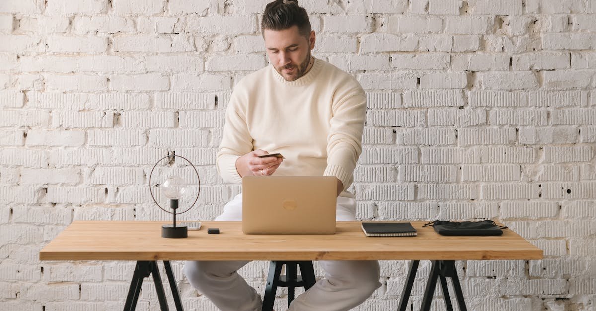 Young man working remotely on laptop in stylish home office setting.