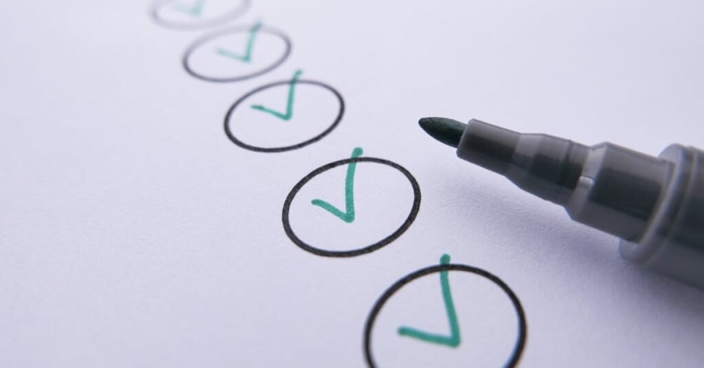 Close-up of a checklist with green checkmarks on white paper using a marker.