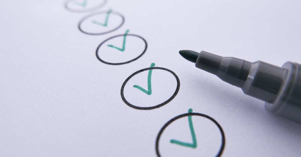 Close-up of a checklist with green checkmarks on white paper using a marker.