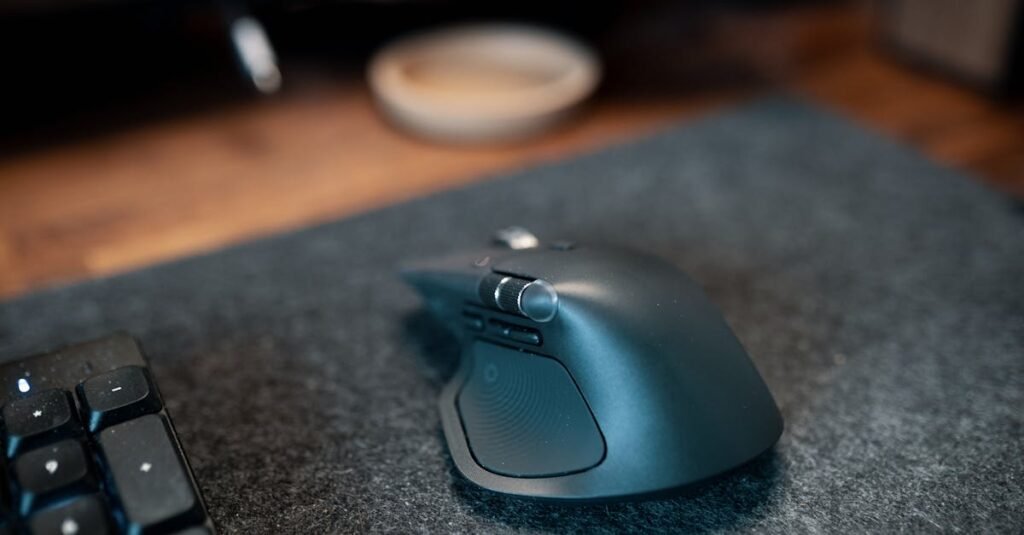 Close-up of an ergonomic wireless computer mouse on a felt desk mat beside a keyboard in an office setting.